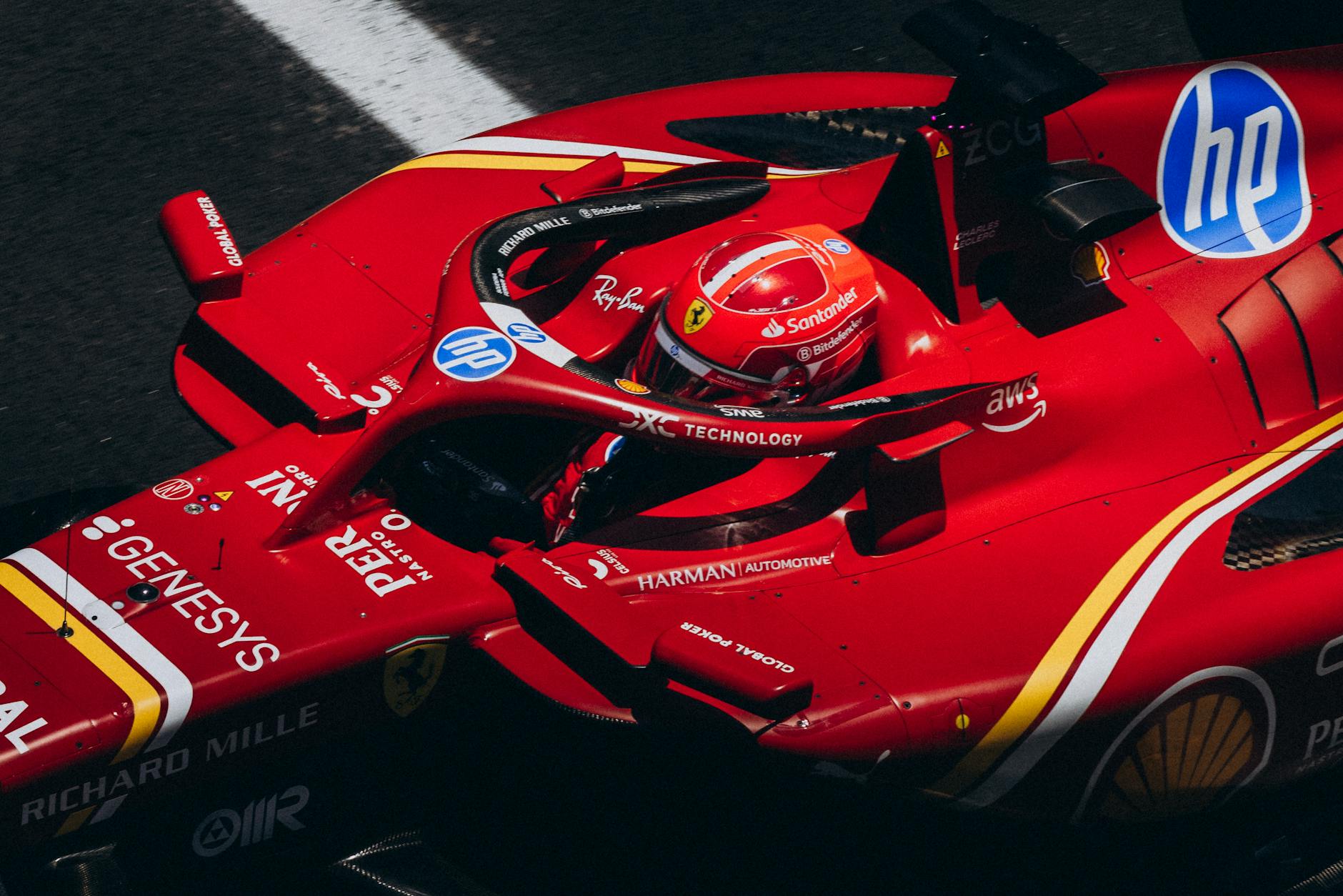 High-speed red racing car zooming down the track, showcasing logos and driver focus.