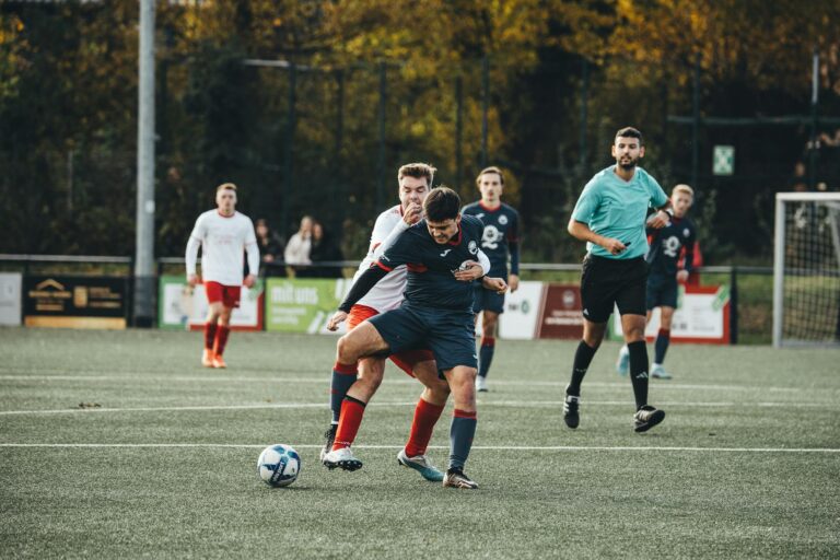 Players in action during an outdoor soccer match on a grass field.