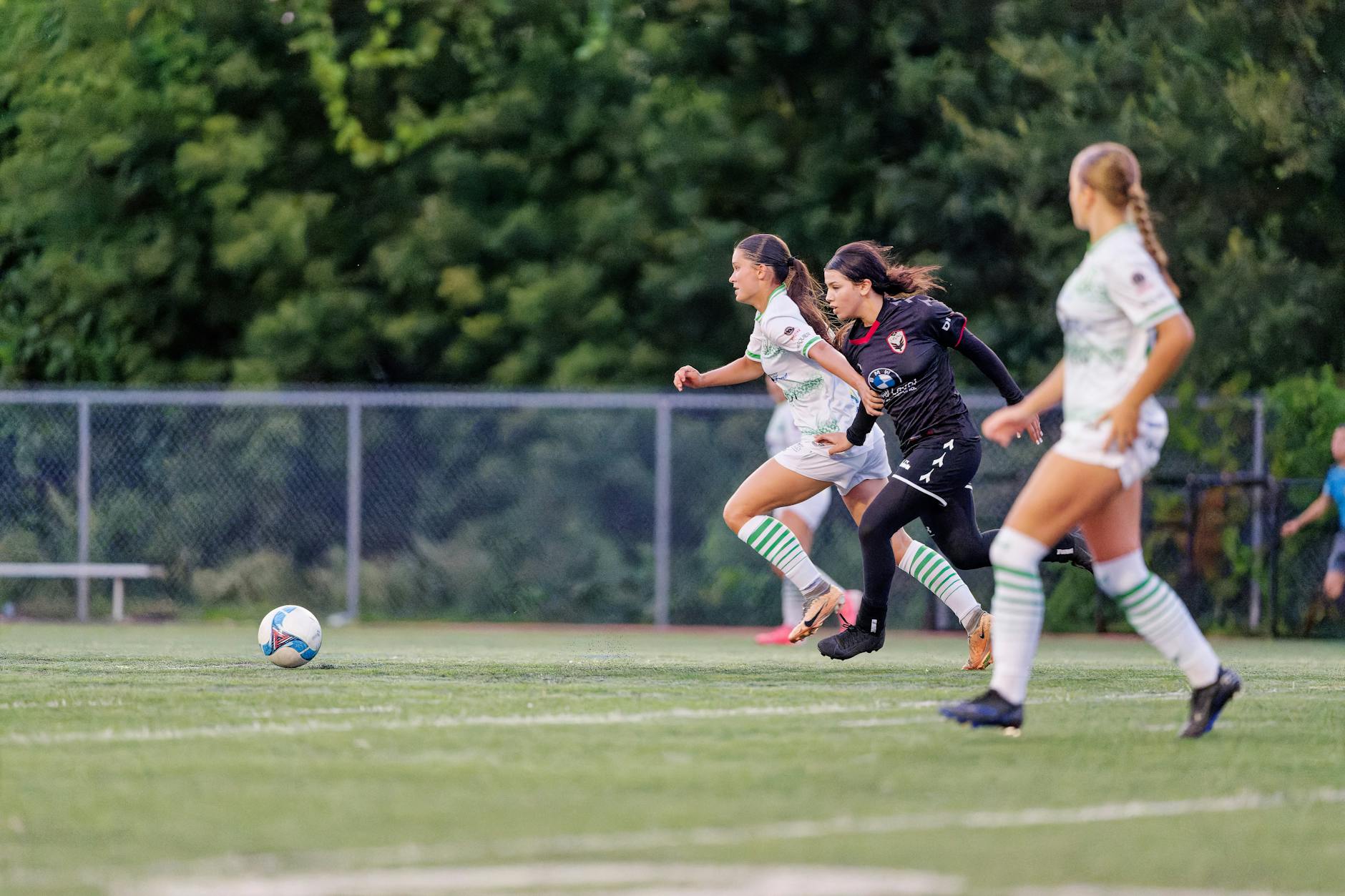 Dynamic action shot of female soccer players competing on the field.