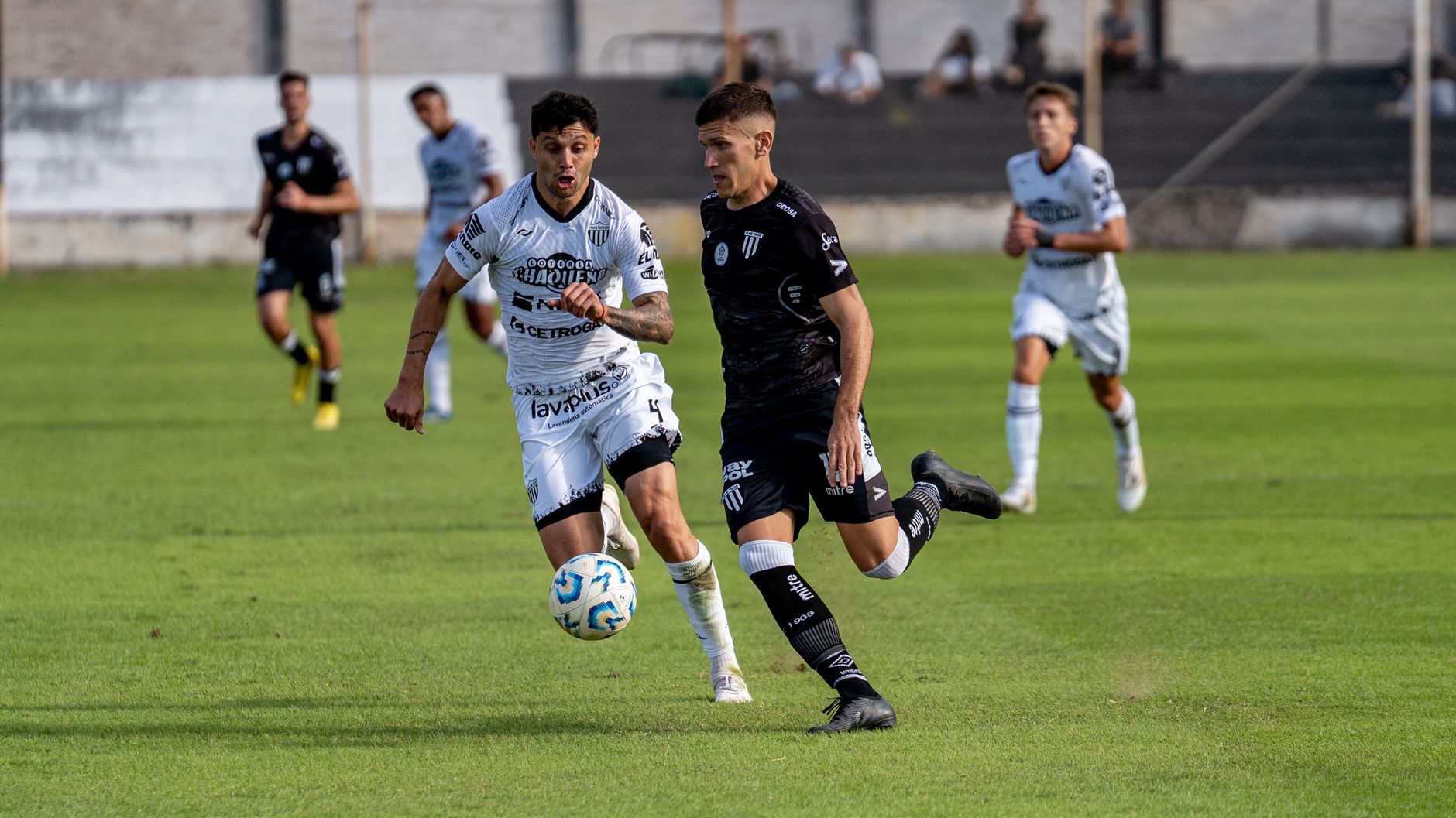Two soccer players competing intensely during a match at a stadium.