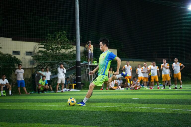 Energetic night soccer match featuring teams in action on a vividly lit field.
