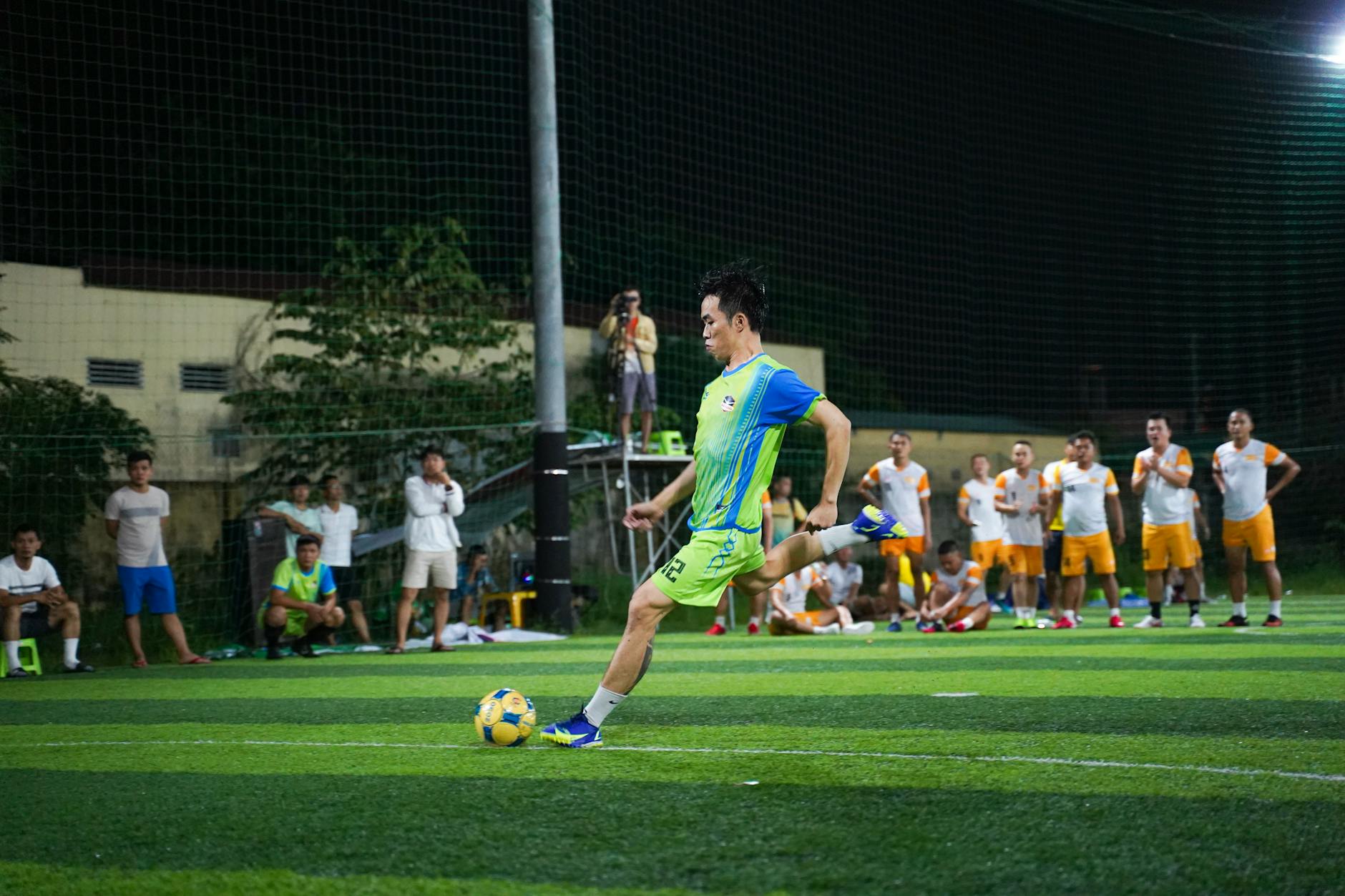 Energetic night soccer match featuring teams in action on a vividly lit field.