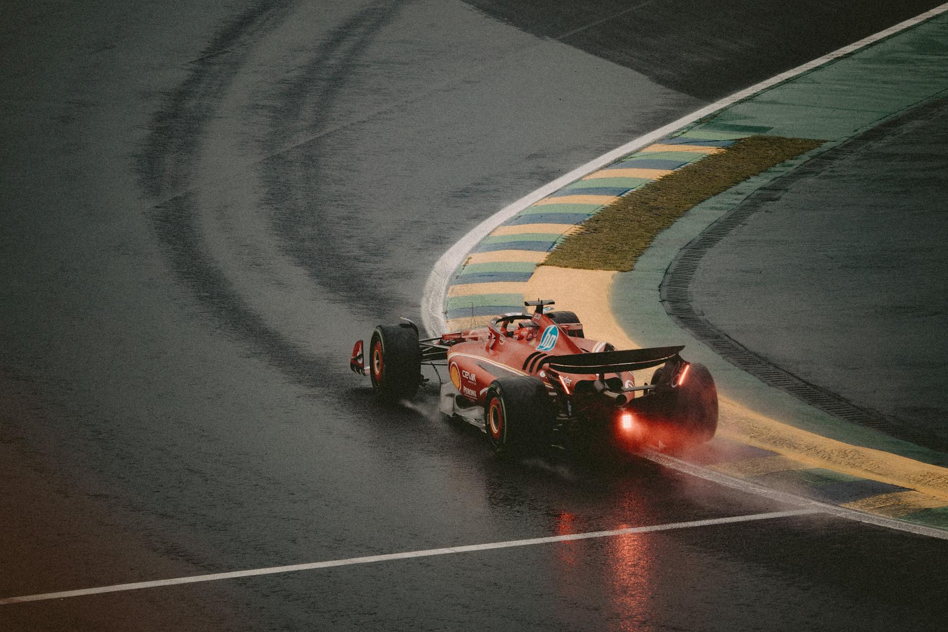 Exciting scene of a red race car taking a sharp turn on a wet track, showcasing speed and precision.
