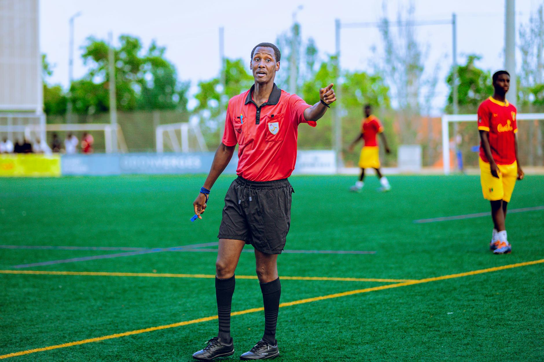 Soccer referee in action on field during a match, guiding players.