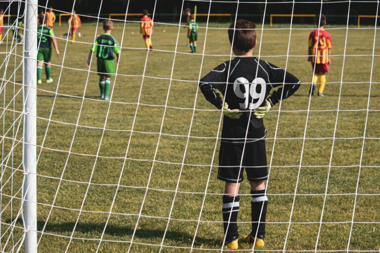 A young goalkeeper stands ready while teammates prepare for the soccer match.