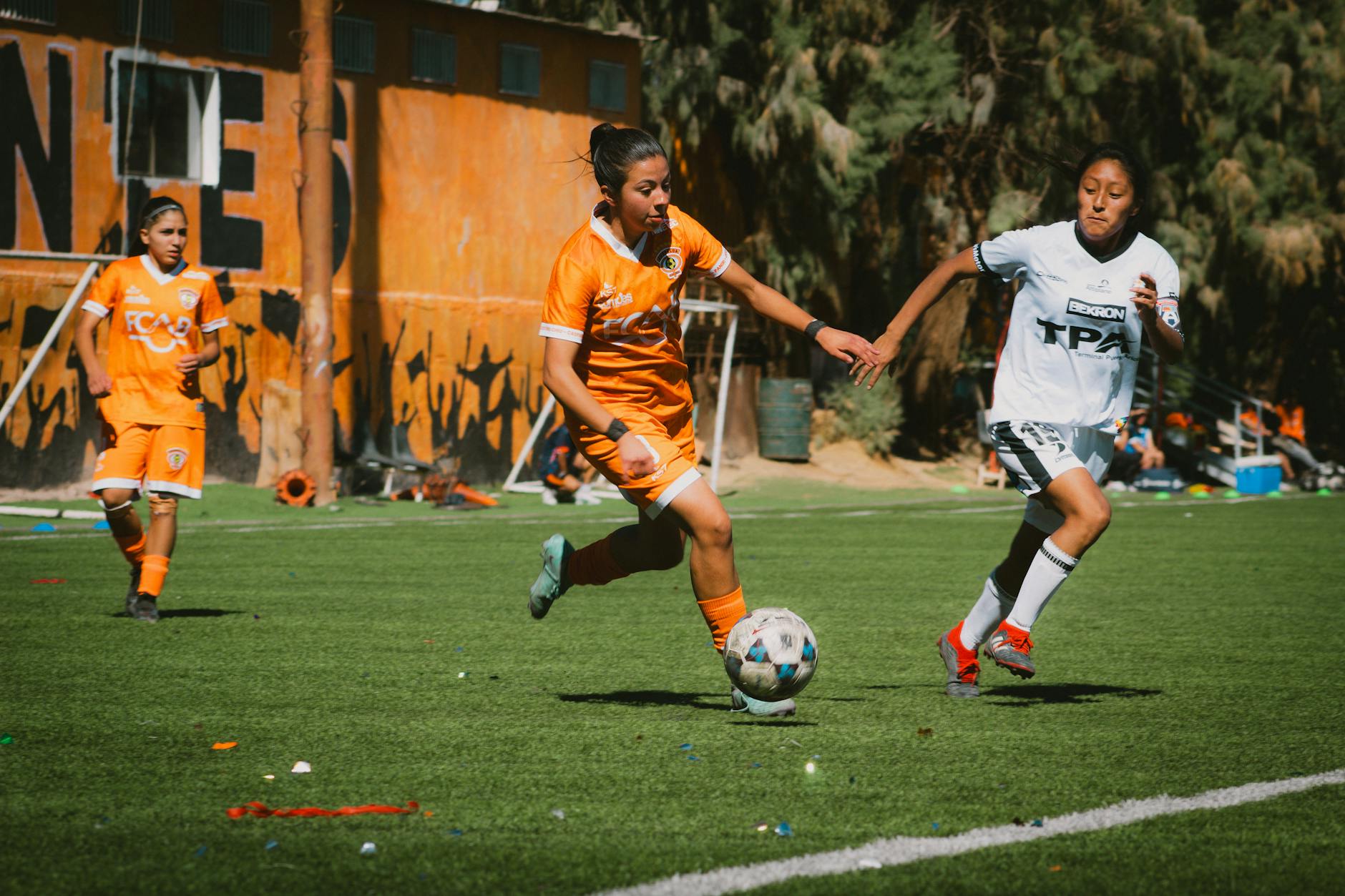 Exciting women's football match with players in action on a sunny day in Chile.