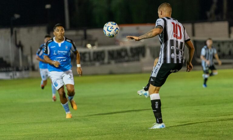 Soccer match intensifies under stadium lights as players compete fiercely on the field.