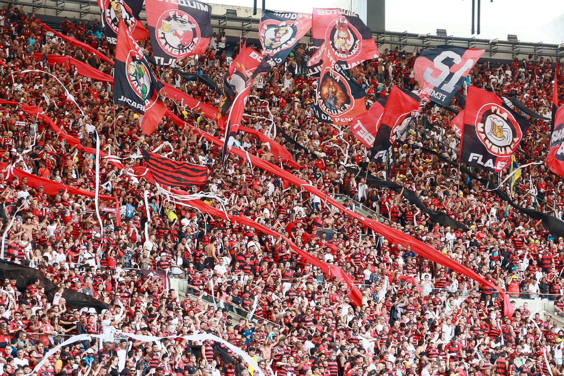 Energetic crowd of Flamengo supporters waving flags in Maracanã Stadium, Rio de Janeiro.