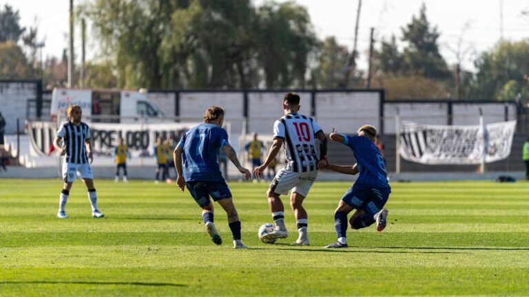 Players engaged in a competitive soccer match on a bright sunny day.