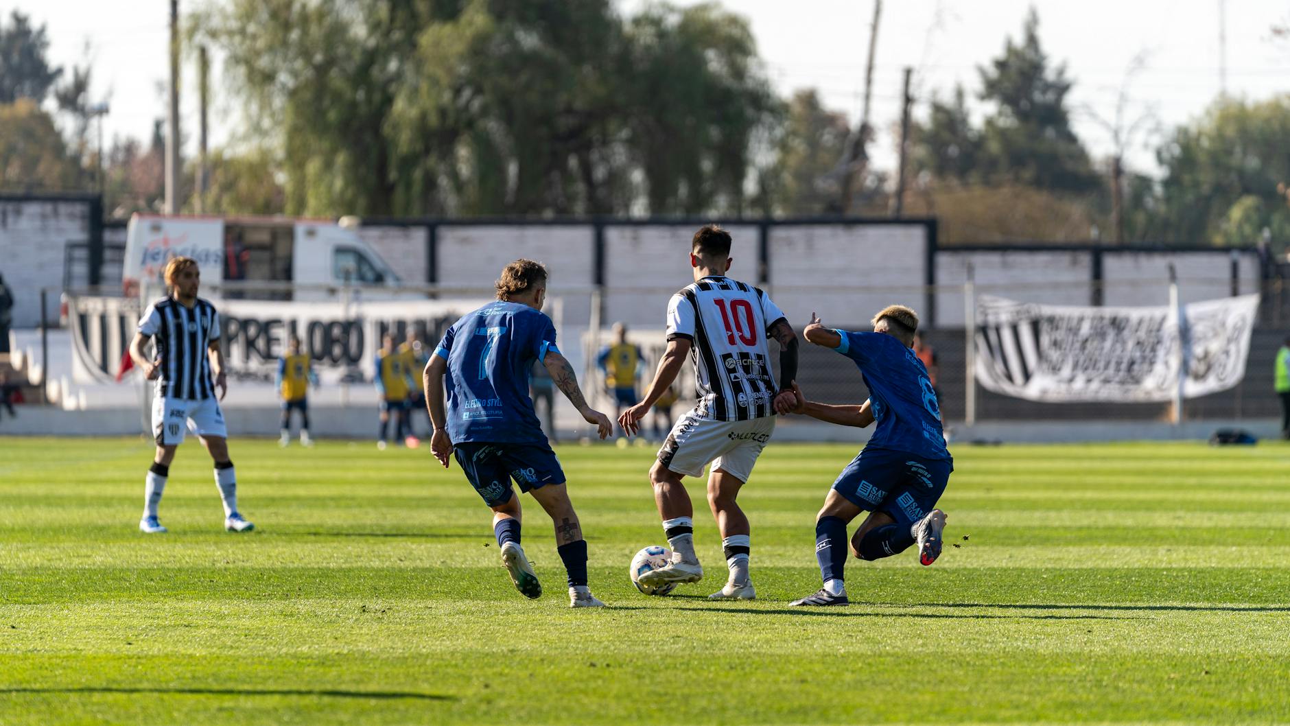Players engaged in a competitive soccer match on a bright sunny day.