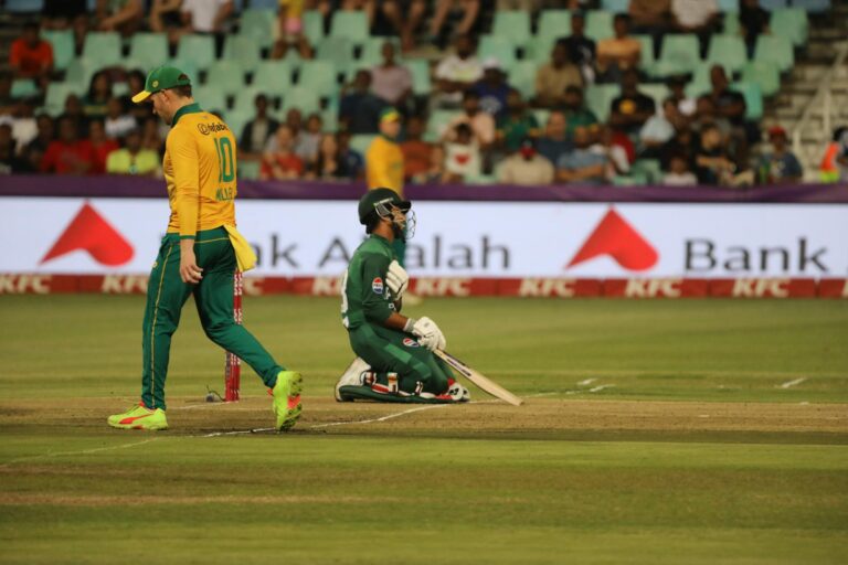 Dynamic cricket scene with players in action on the field during a match.