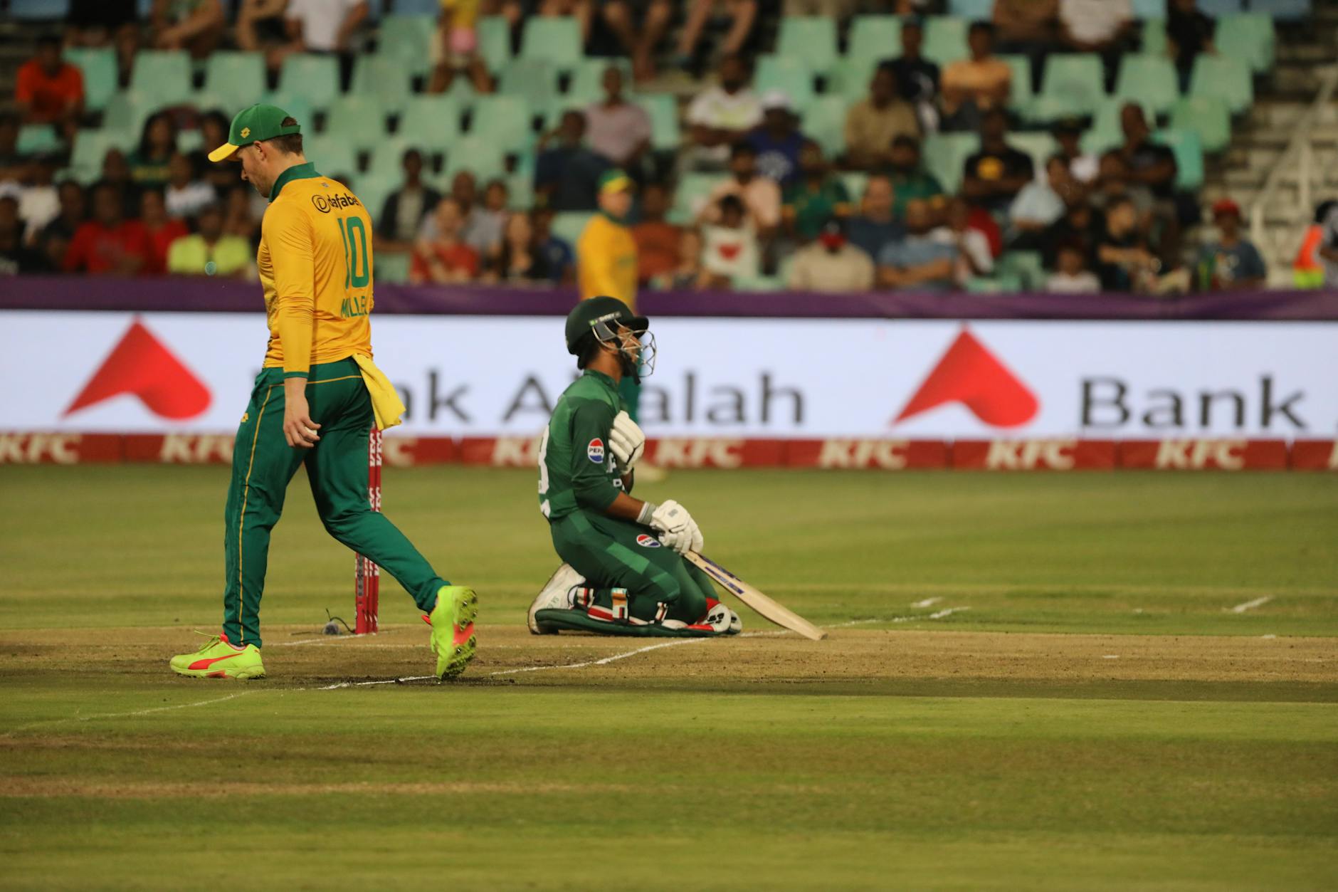 Dynamic cricket scene with players in action on the field during a match.
