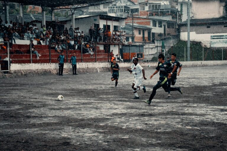 Exciting soccer game in Neira, Colombia, capturing athletes in action during a rainy match.