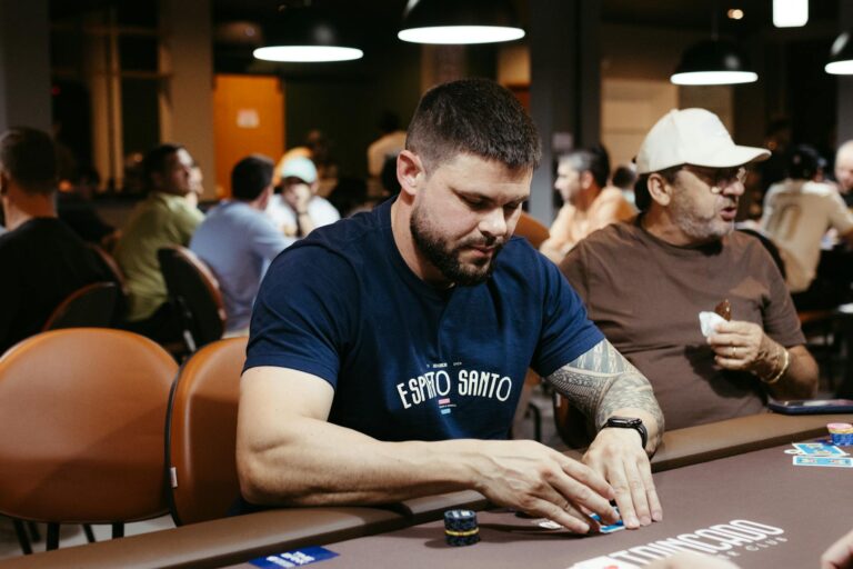 A poker player concentrating during a game in a lively casino atmosphere.