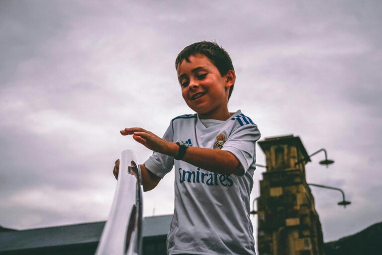 Cheerful young boy having fun outdoors on a cloudy day.