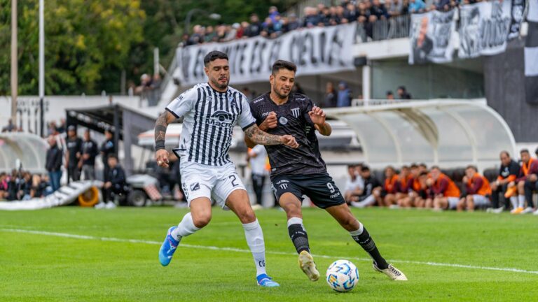 Two soccer players in action during a competitive match outdoors.