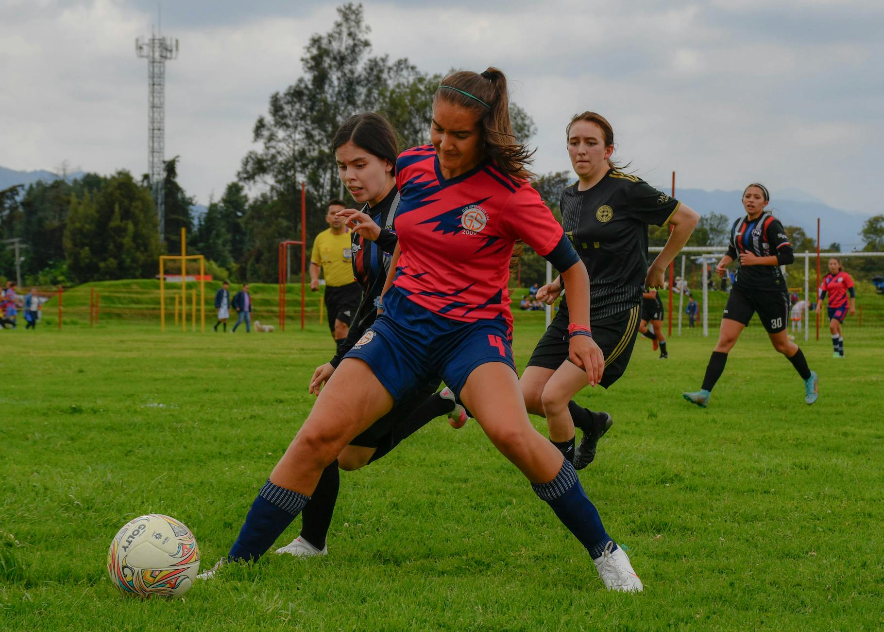 Action-packed scene of female athletes competing in a soccer game outdoors.