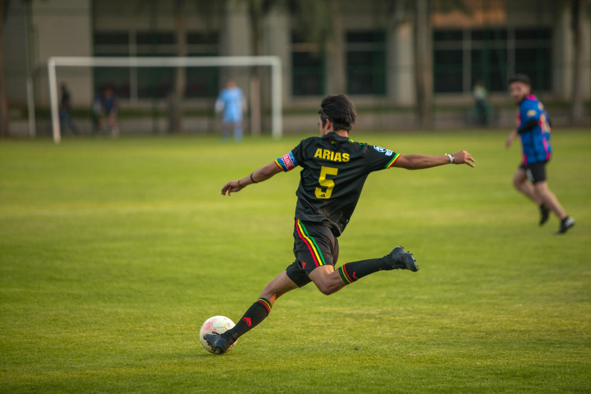 Dynamic shot of a soccer player in action during a match on a grassy field.