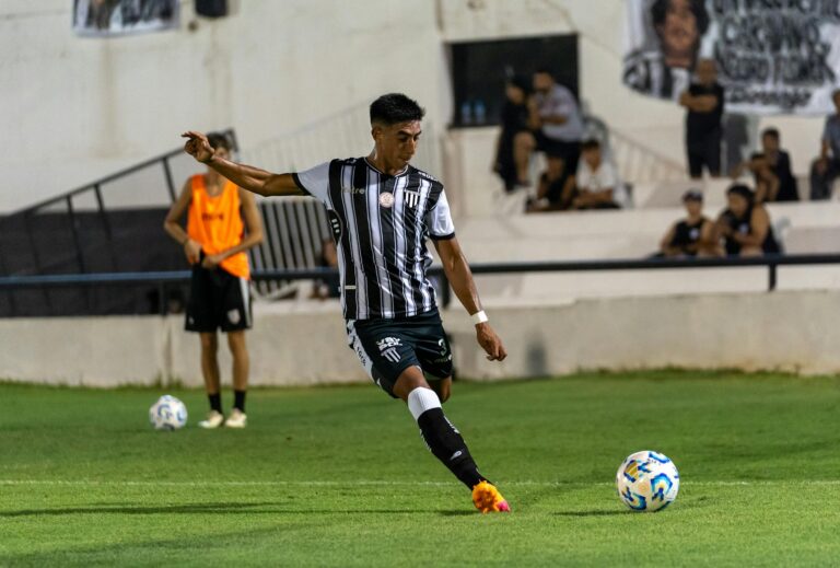 An intense moment as a soccer player executes a powerful kick on the field during a competitive match.