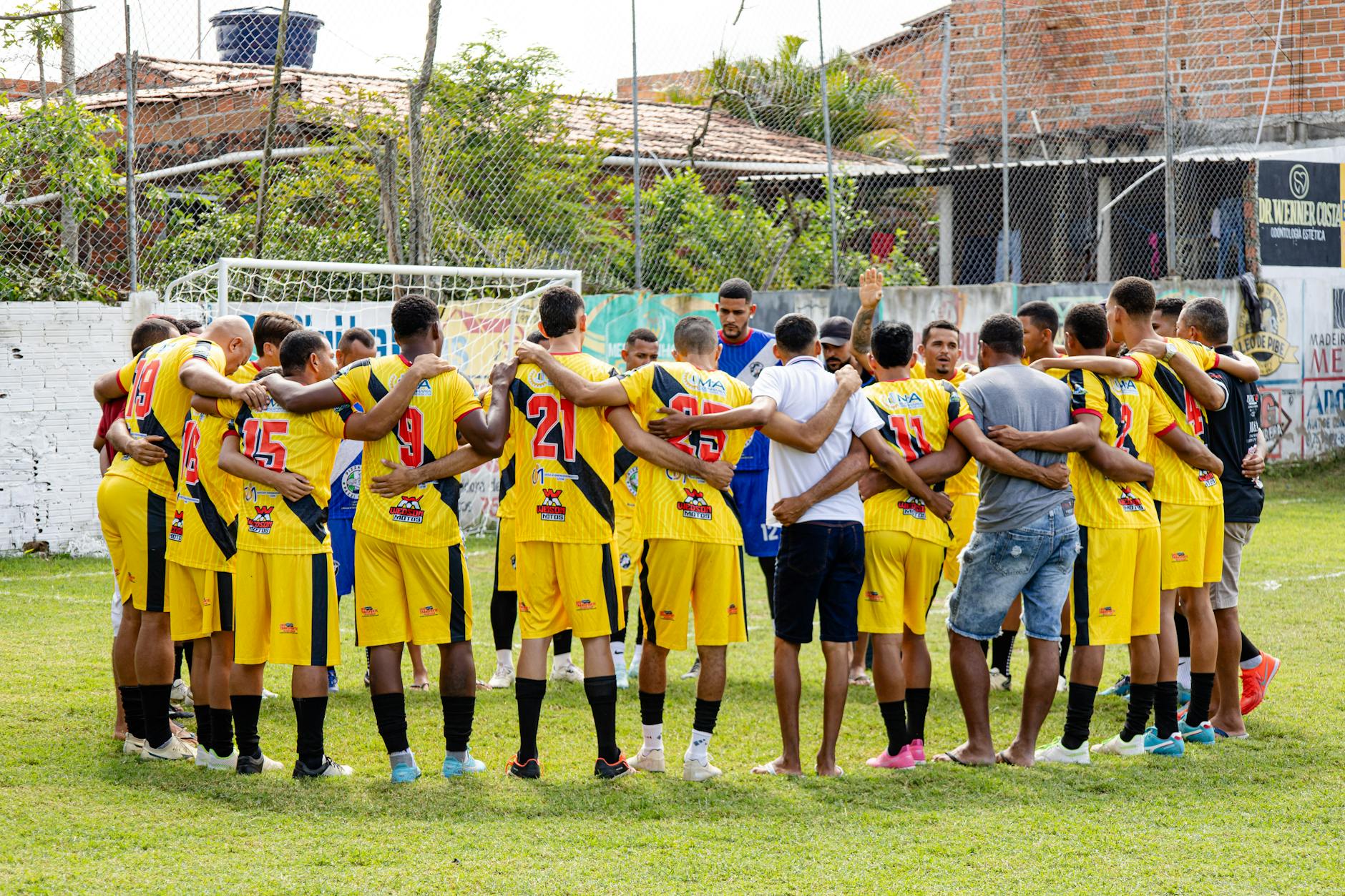 Amateur soccer players huddle on the field, preparing for their match with motivational energy and teamwork.