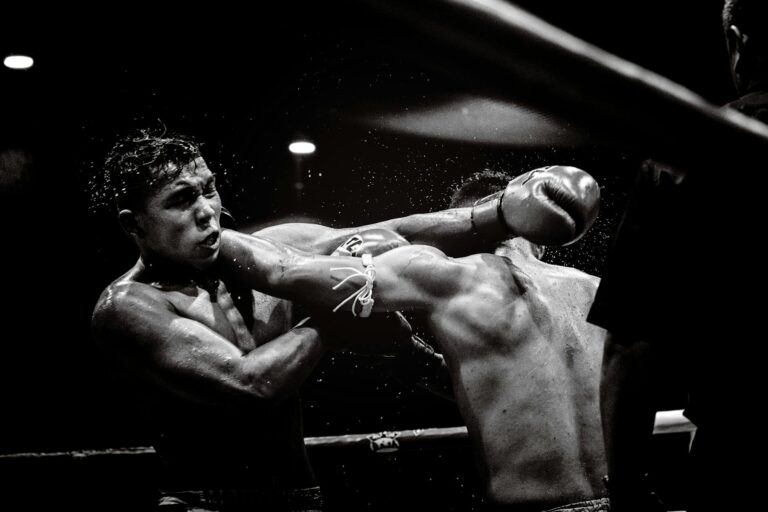 Dynamic black and white photo capturing a powerful moment in a boxing match.