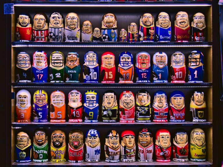 Colorful nesting dolls depicting various sports teams displayed on shelves.