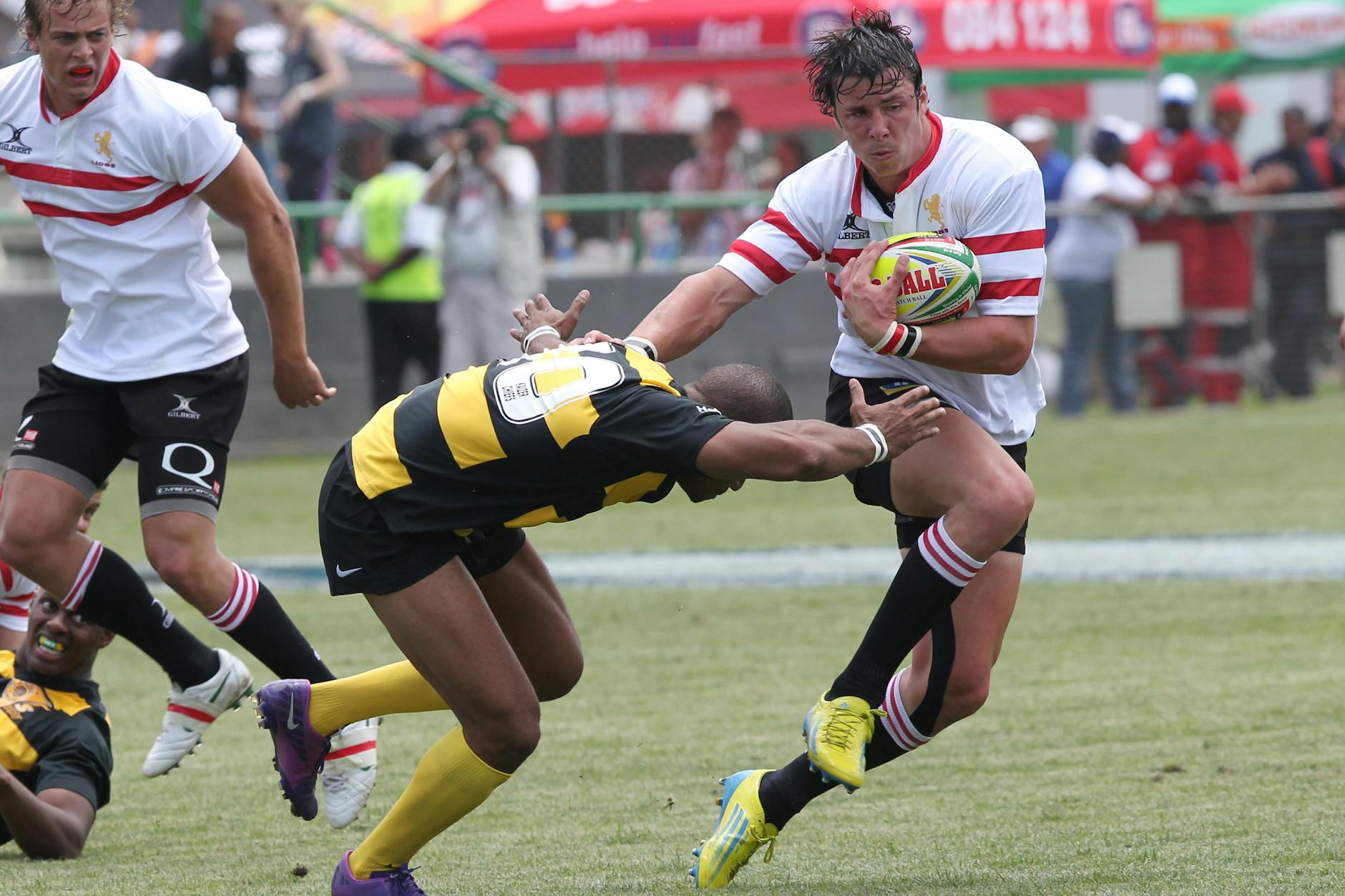 Action-packed rugby scene capturing a dramatic tackle during a competitive match.