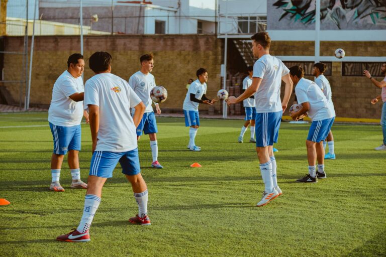 Dynamic image of a youth soccer team engaging in training drills on a sunny day.
