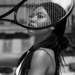 Artistic portrait of an African American woman with a tennis racket. Black and white.