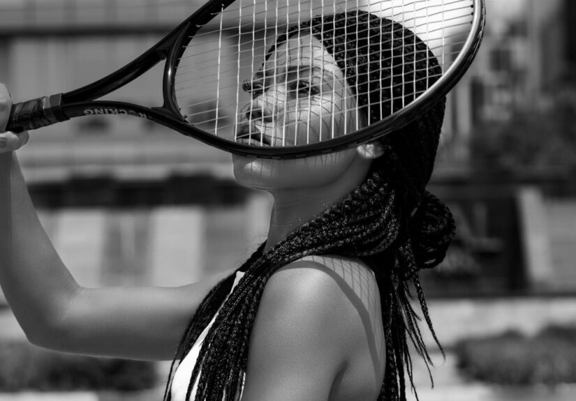 Artistic portrait of an African American woman with a tennis racket. Black and white.