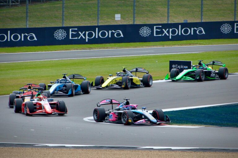 Thrilling Formula race at Silverstone Circuit with colorful cars competing for the lead on the track.