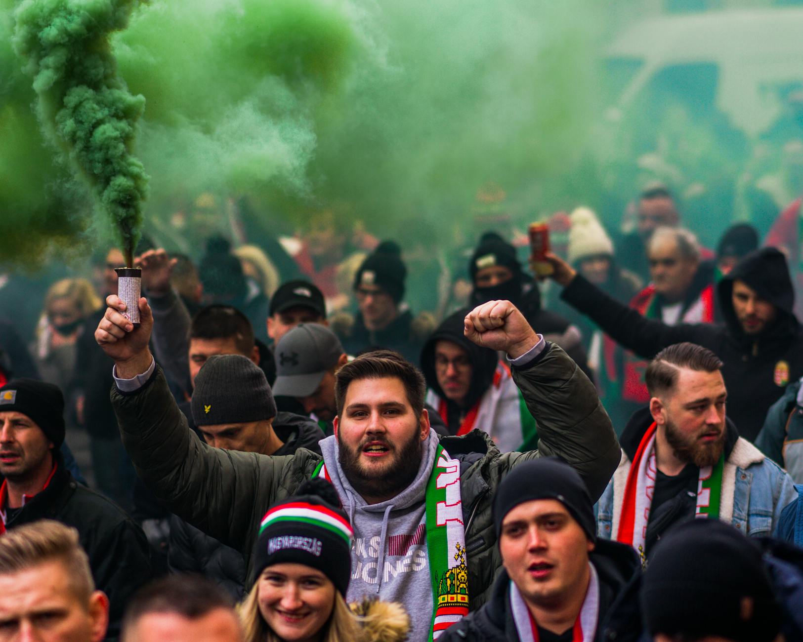 A vibrant crowd of football fans celebrating with smoke flares, showcasing passion and unity.