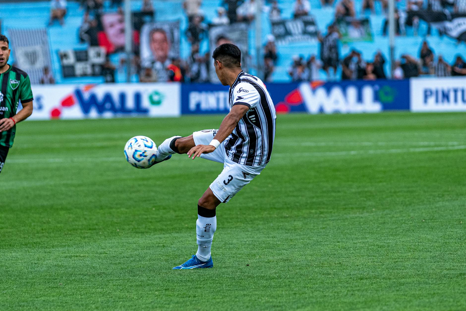 Dynamic shot of a soccer match with players in action on a grassy field.