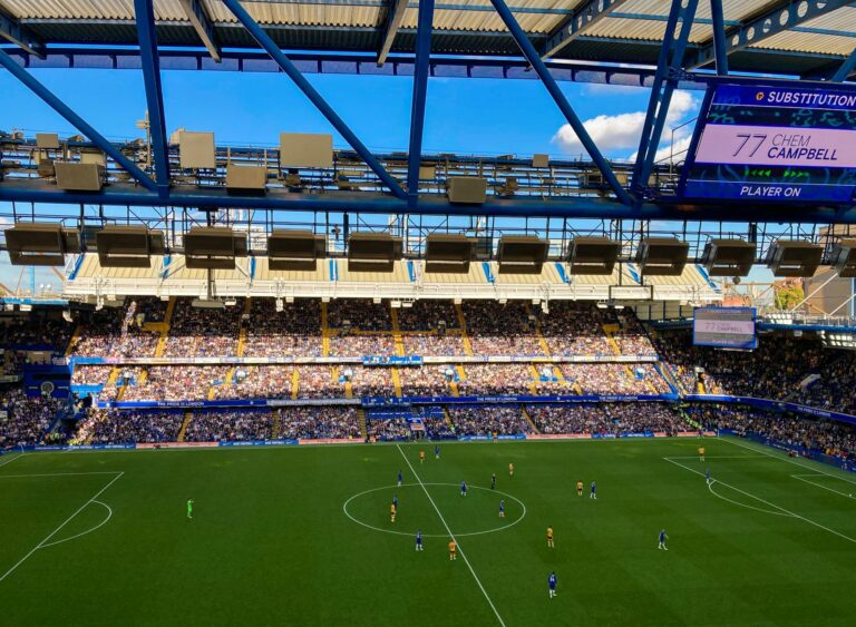 A lively football match in Stamford, England capturing the crowd and players in a filled stadium.