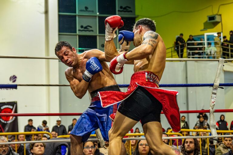 Dynamic capture of two boxers in a heated championship fight indoors.
