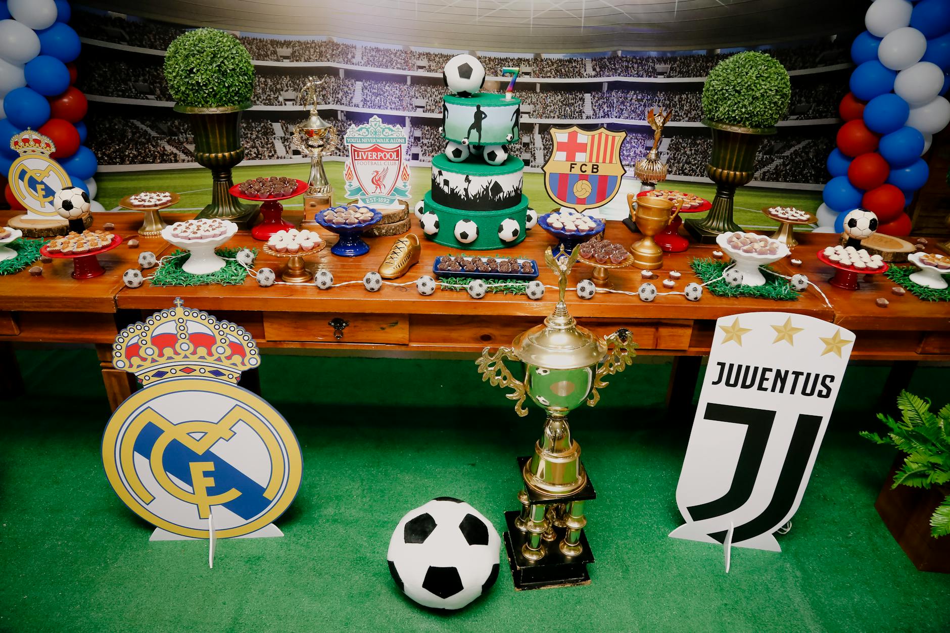 A vibrant football-themed dessert table with cakes, pastries, and iconic team logos, perfect for sports events or celebrations.