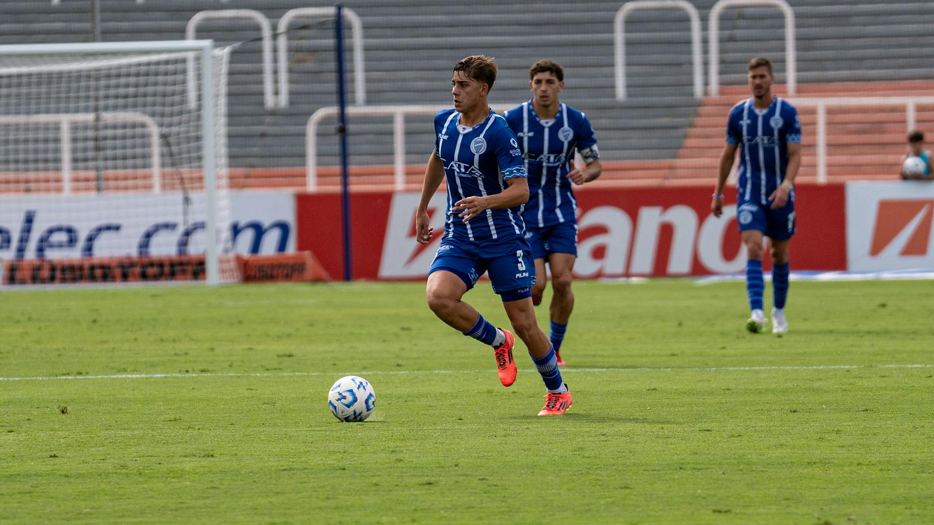Exciting action shot of soccer players in blue jerseys during a match.