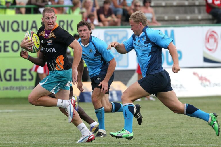 Dramatic moment captured during a competitive rugby match with players in action on the field.