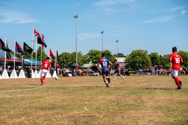 Dynamic action shot of a football match in Aldershot, England with players mid-game.
