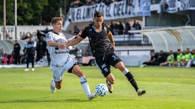 Two soccer players in action during a competitive outdoor match.