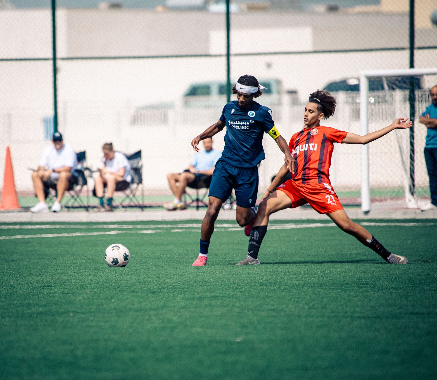 A dynamic moment in an outdoor soccer match with two players in action, competing for the ball.