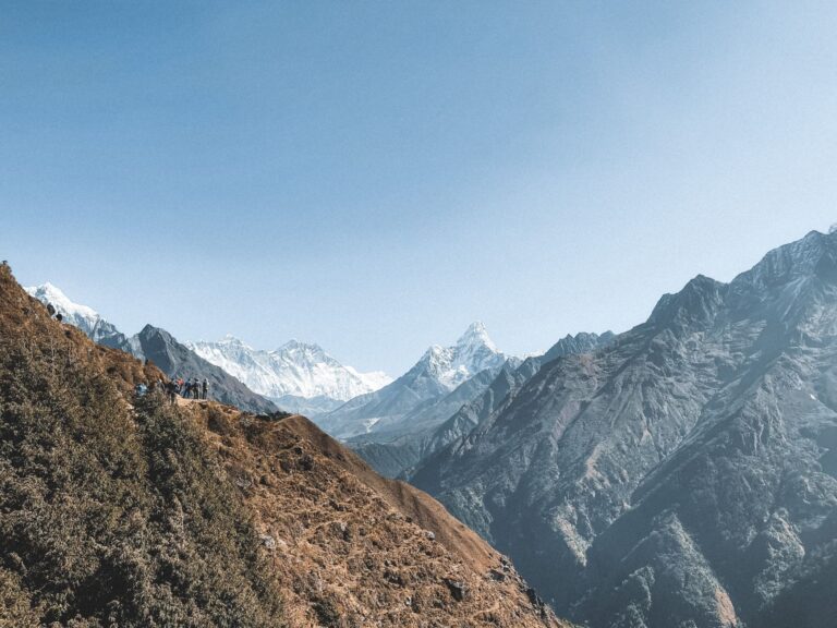 A stunning view of the Himalaya Mountains with hikers traversing the scenic mountain path in Nepal.