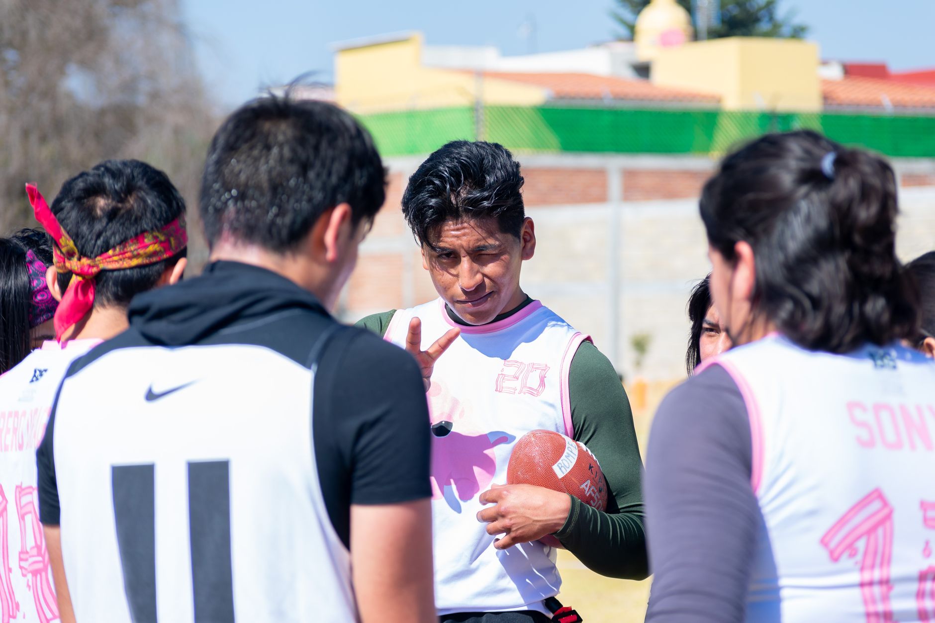 A youth football team strategizing during practice in Toluca de Lerdo, Mexico.