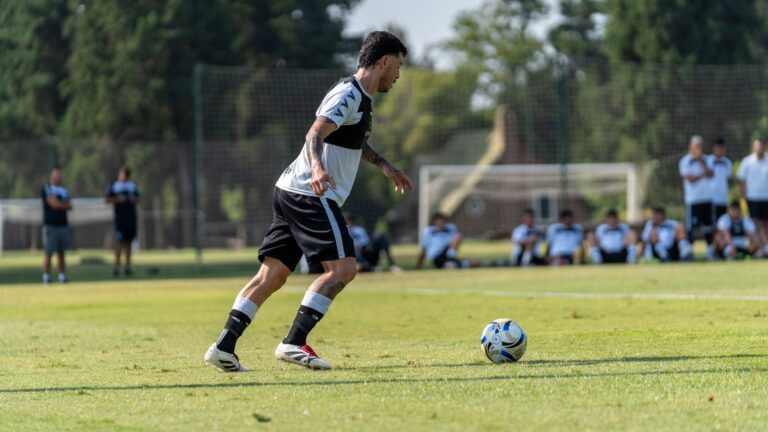 A soccer player skillfully dribbles the ball during an outdoor training session.