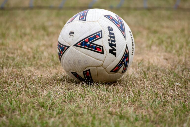 Close-up of a soccer ball on dry grass in Tipton, England. Perfect for sports and recreation themes.