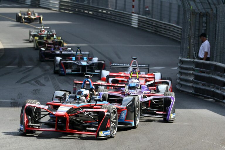 Thrilling Formula E cars racing through Monaco's iconic circuit, showcasing speed and competition.