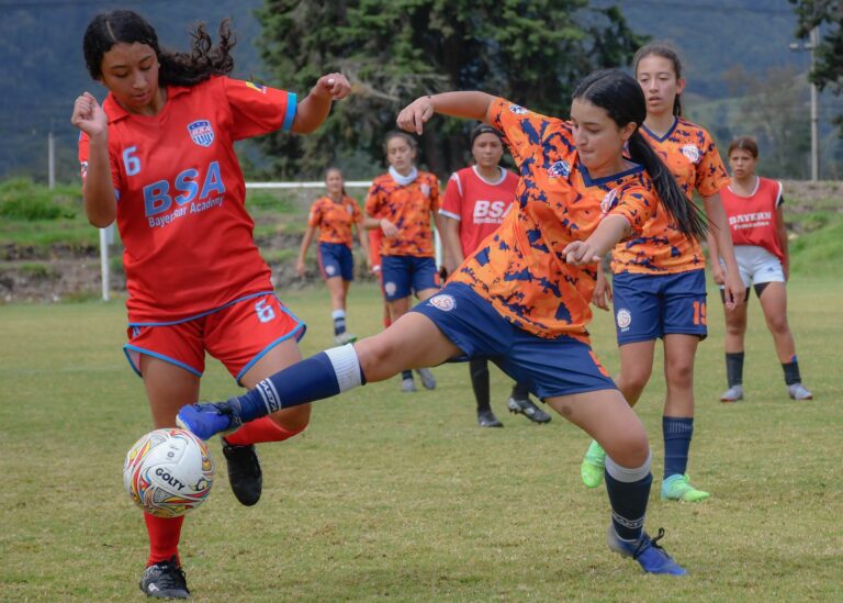 Energetic girls' soccer game showcasing skill and teamwork on a vibrant day.