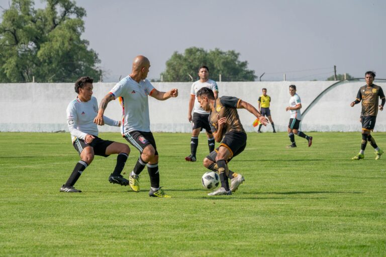 Dynamic soccer match featuring players in motion on a sunny outdoor field.
