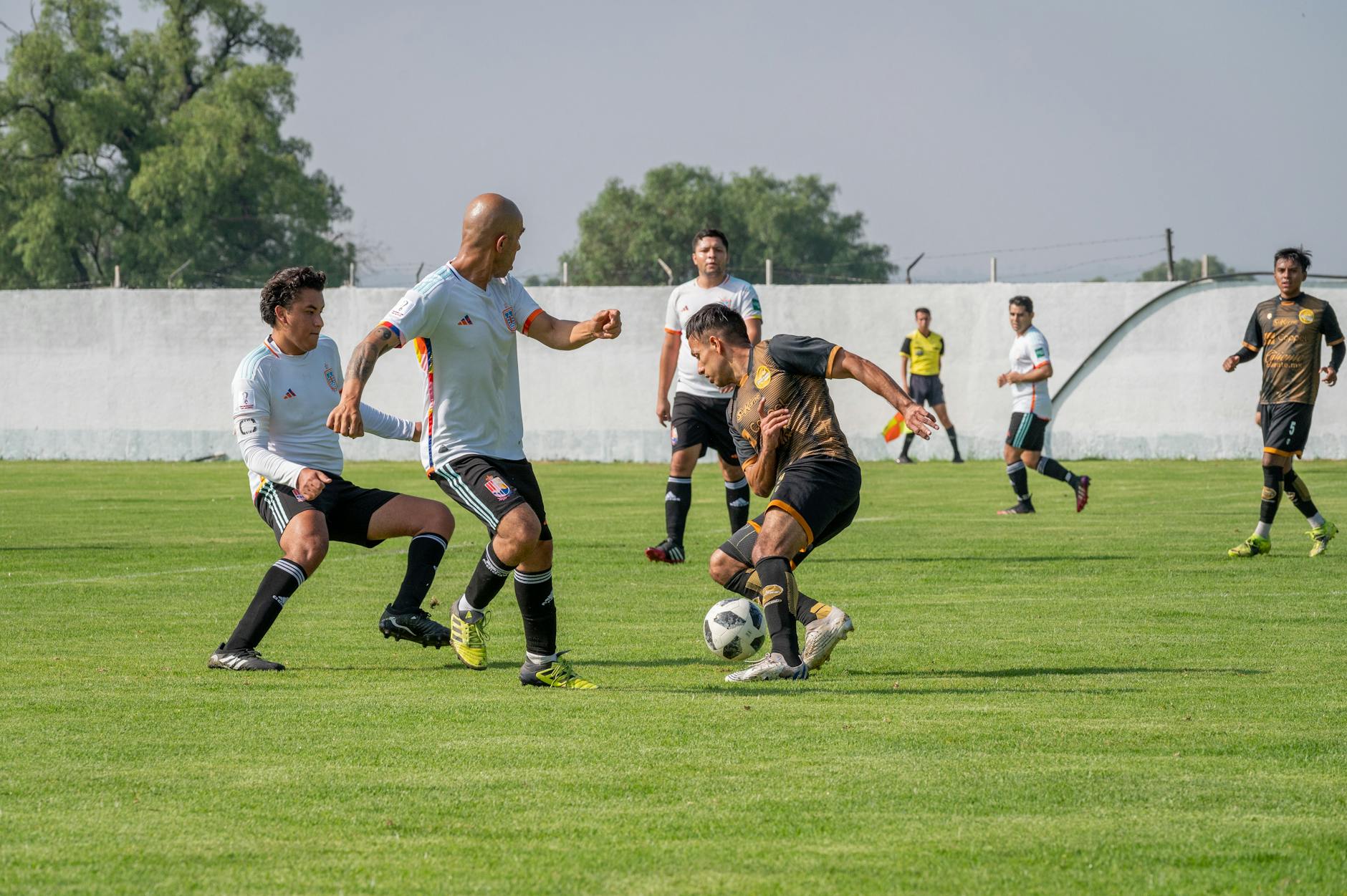 Dynamic soccer match featuring players in motion on a sunny outdoor field.