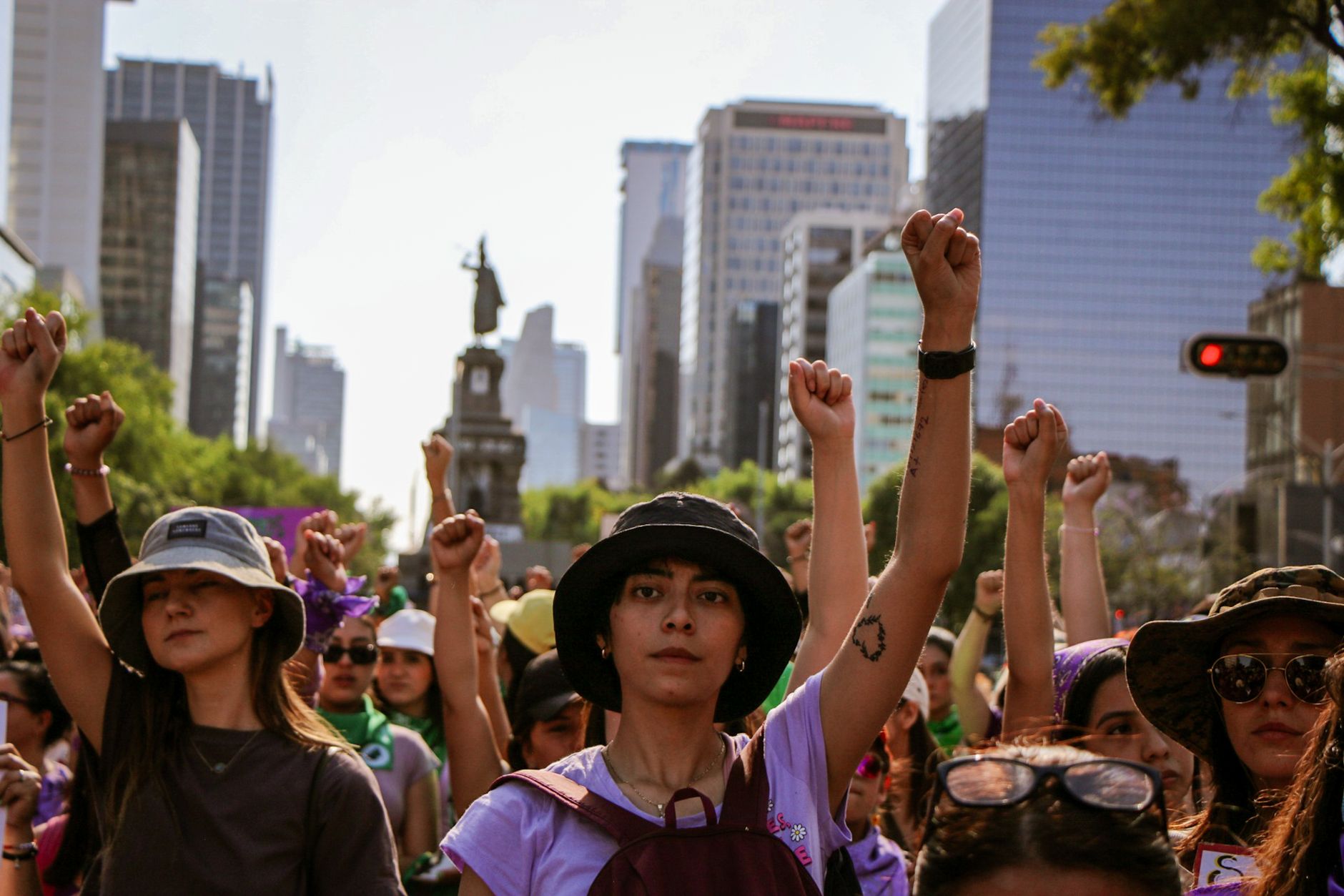 A vibrant women's march in a downtown area with participants raising fists in solidarity.